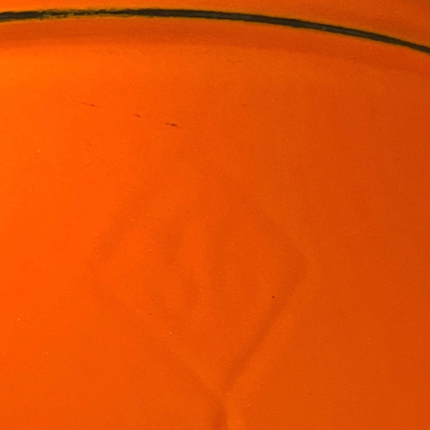 close up of Le Creuset cast iron orange dish on a white background