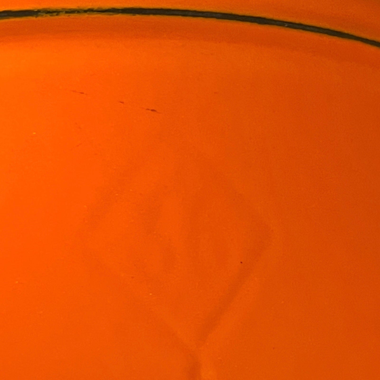 close up of Le Creuset cast iron orange dish on a white background