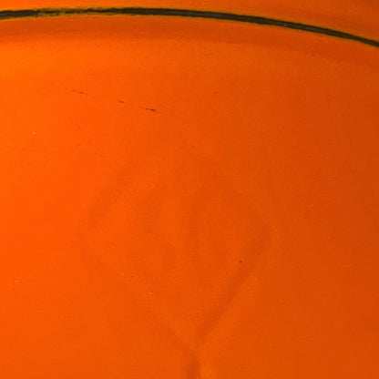 close up of Le Creuset cast iron orange dish on a white background