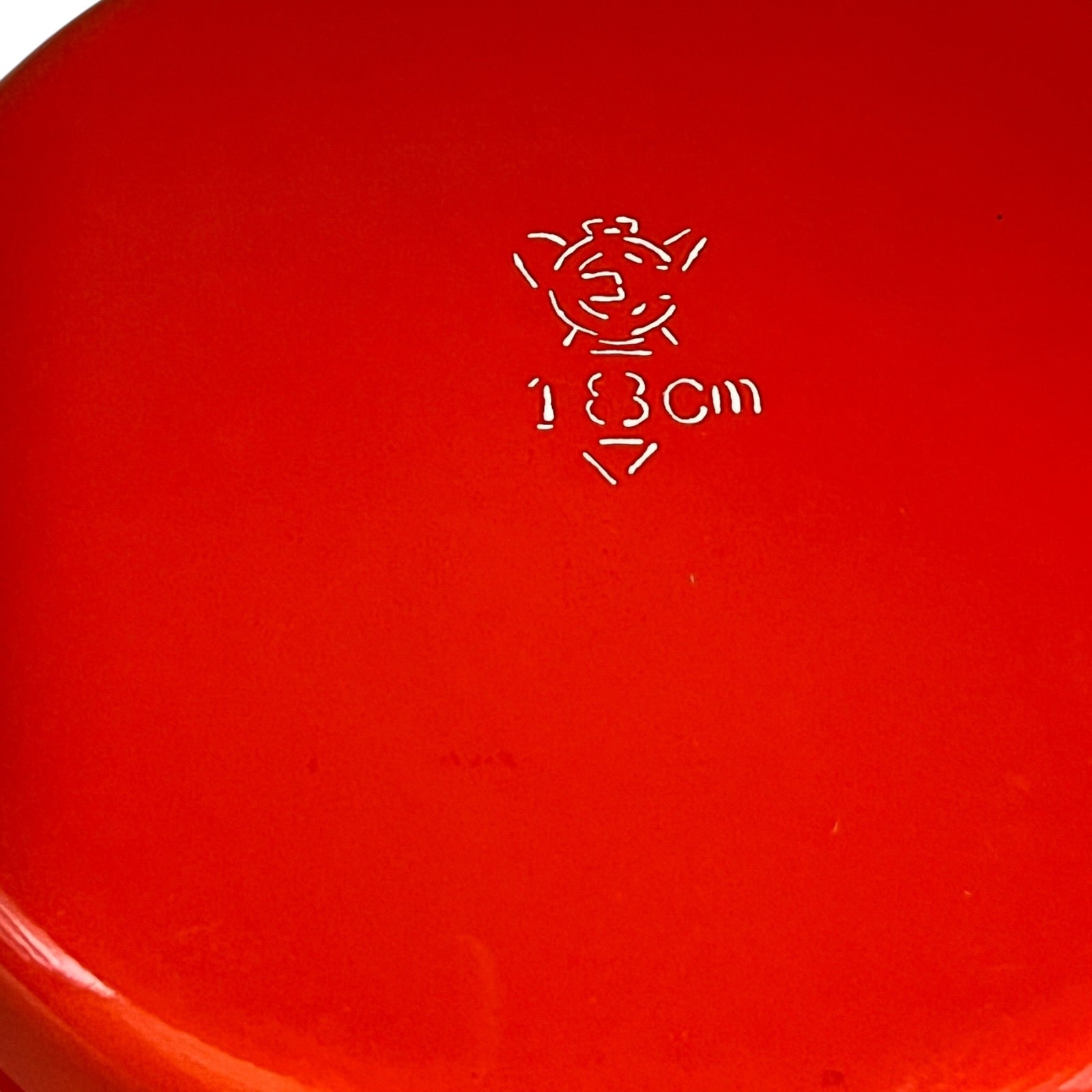 Close-up of a red enamel skillet on a white background