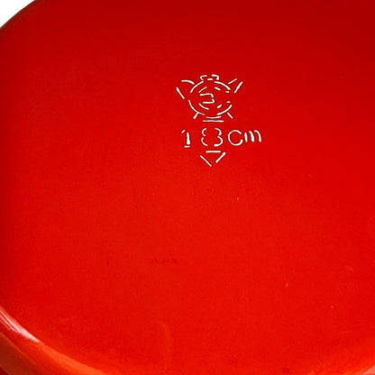 Close-up of a red enamel skillet on a white background