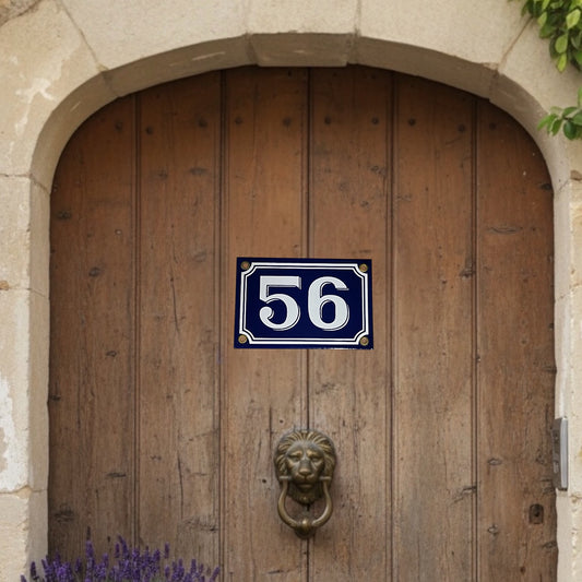 Wooden door with a blue and white number plate and lion knocker.