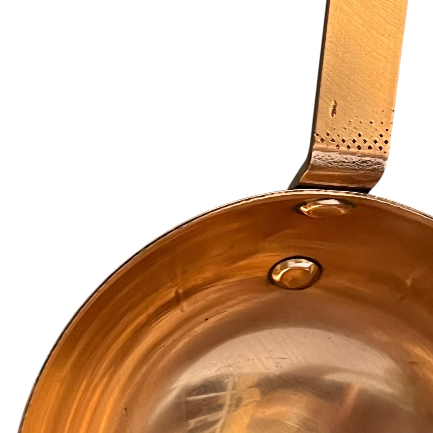 Close-up of a copper ladle with a handle on a white background