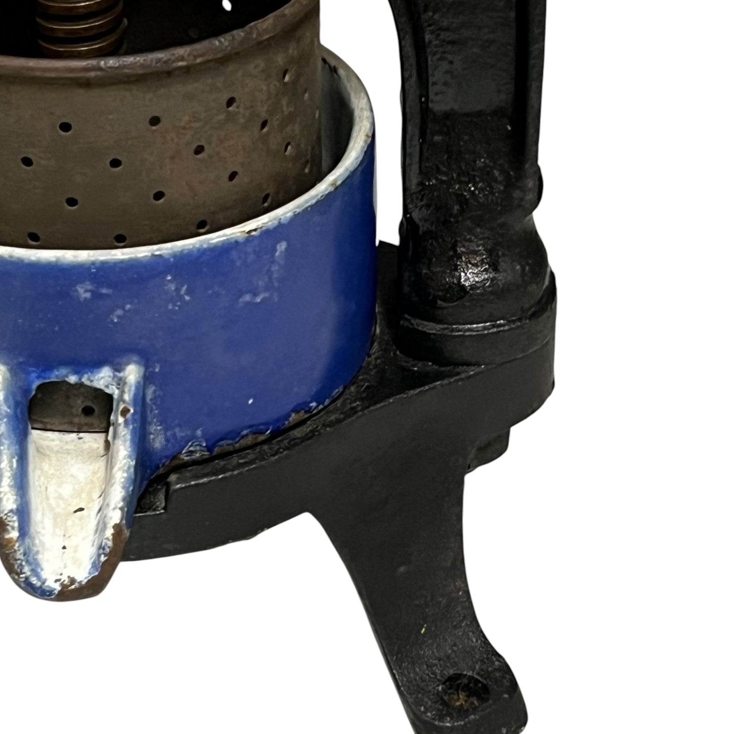 Close-up of a vintage fruit press with a black handle on a white 