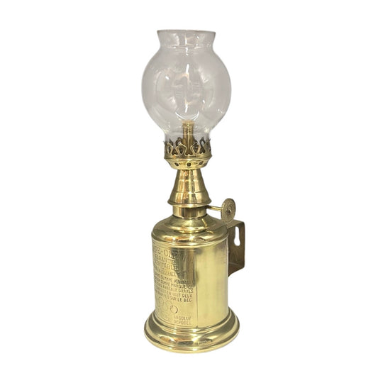 Brass oil lamp with clear glass shade on a white background