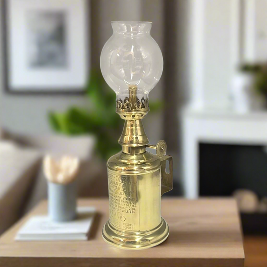 Brass oil lamp on a wooden table with a blurred background