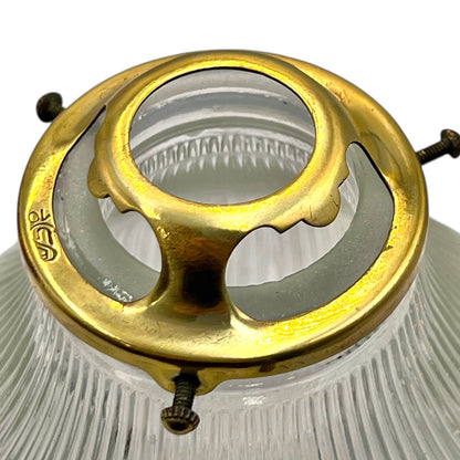 Close-up of a brass lampshade finial with clear glass background