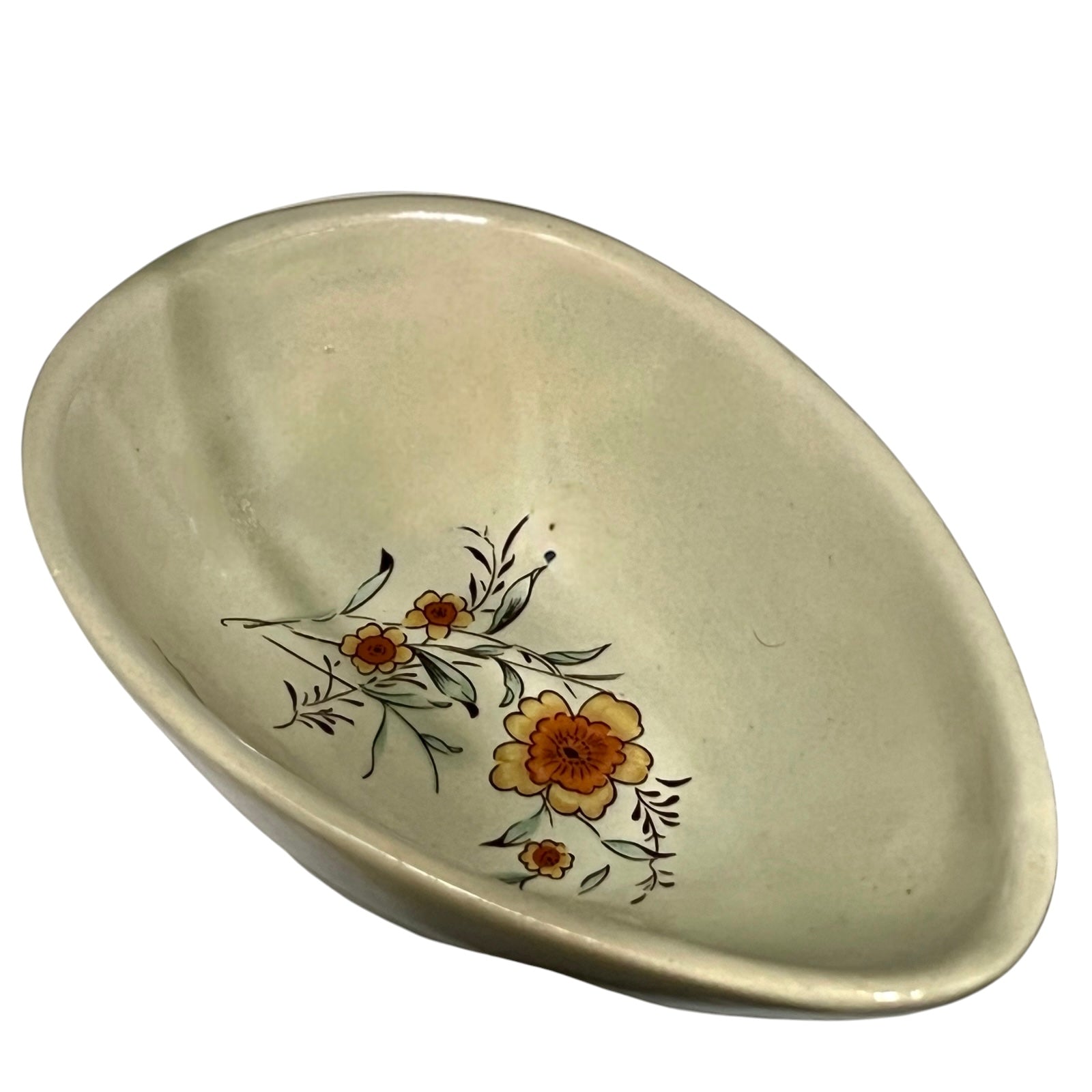 Beige ceramic dish with floral design and 'L'avocat' text on a white background