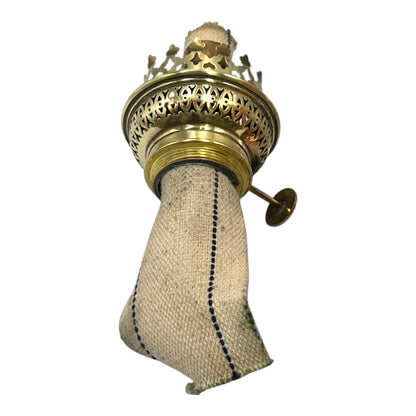 Decorative oil lamp with brass top and fabric wick on a white background