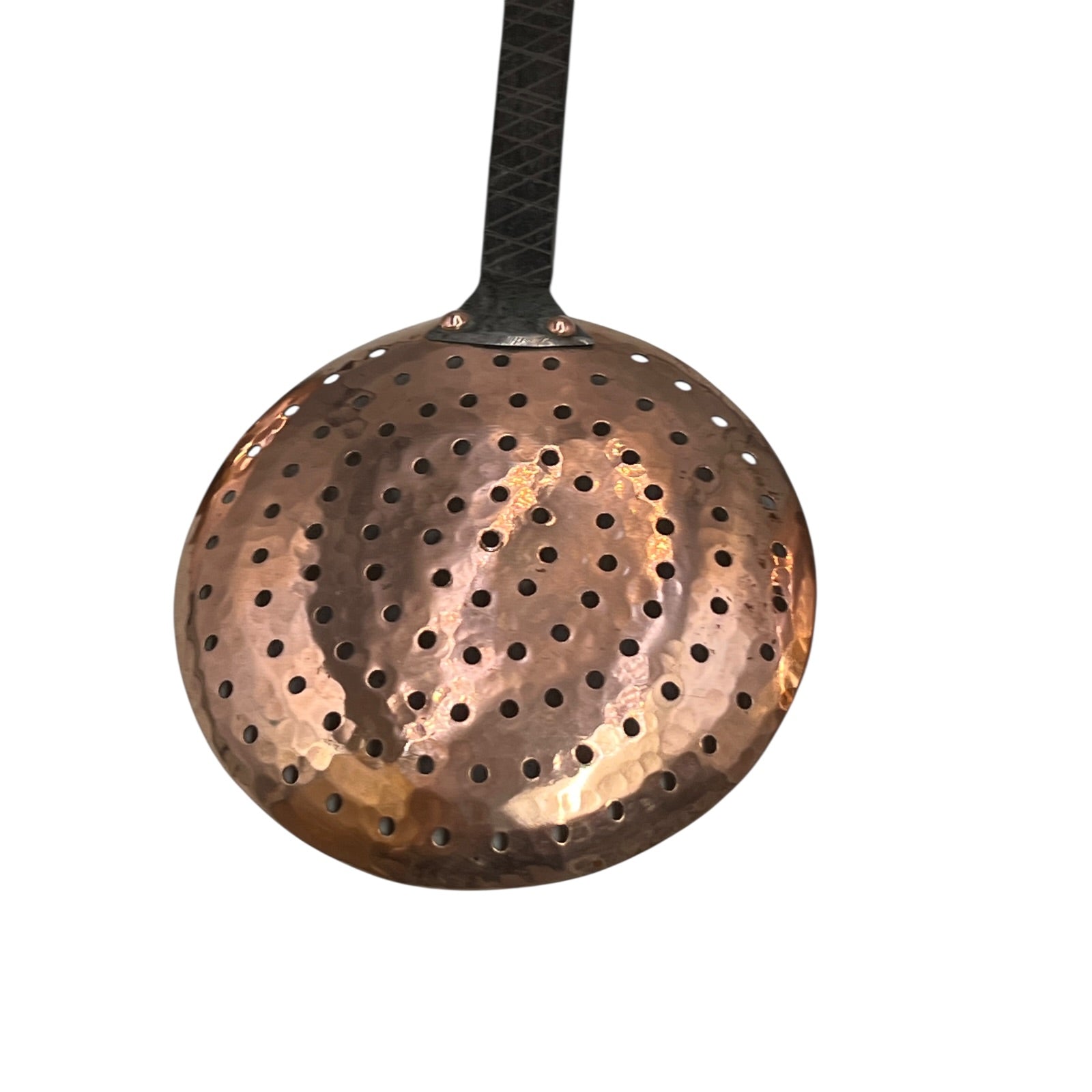 Close up of French copper kitchen utensils with black handles on a white background