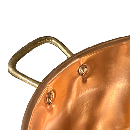 Close up of handle in a copper sink shown in a white background 