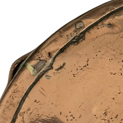 Close up of a copper roasting pan with a long handle on a white background