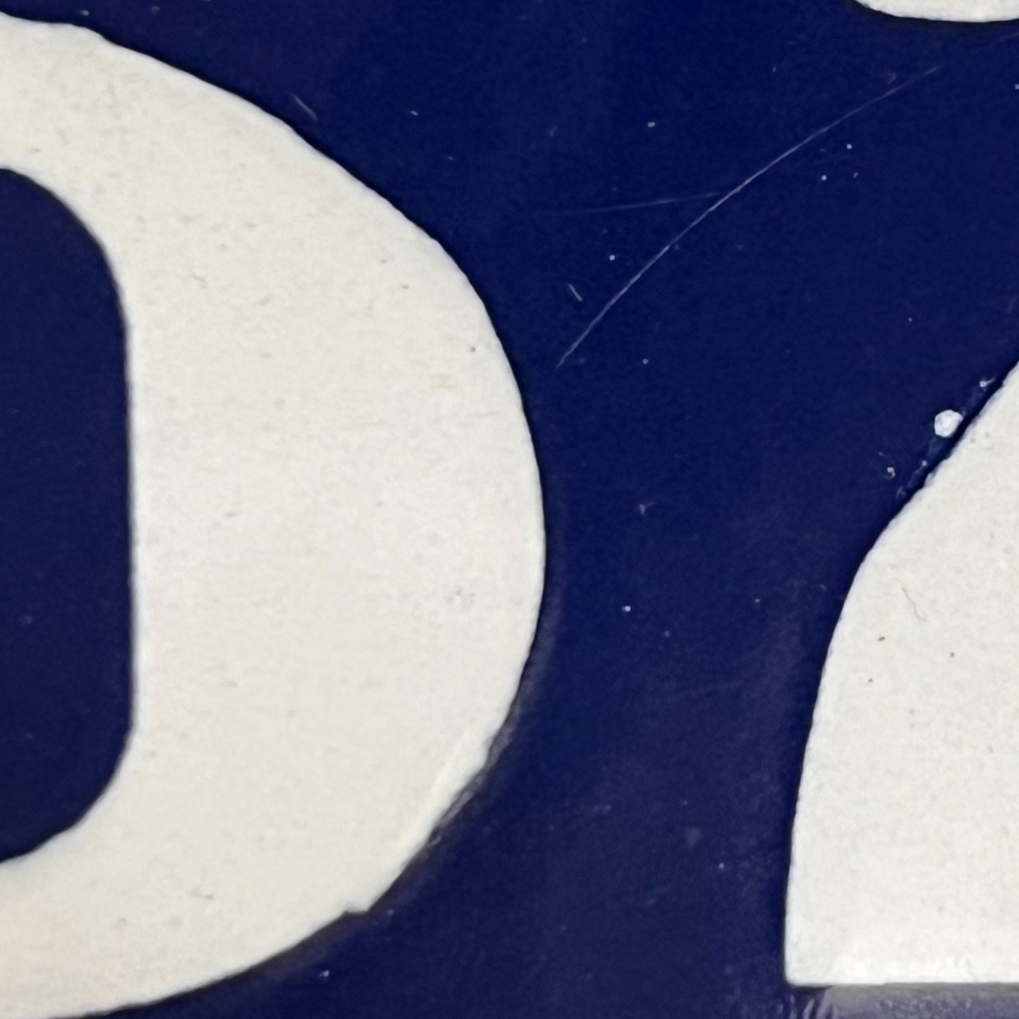Close-up of a blue and white logo on a textured surface