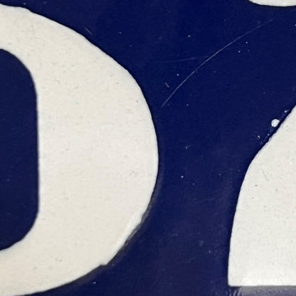 Close-up of a blue and white logo on a textured surface