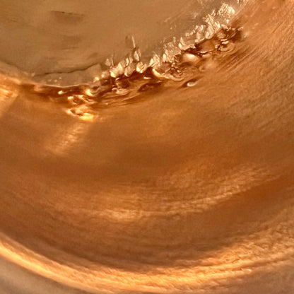 Close up of French vintage copper ladle pan with a black handle on a white background