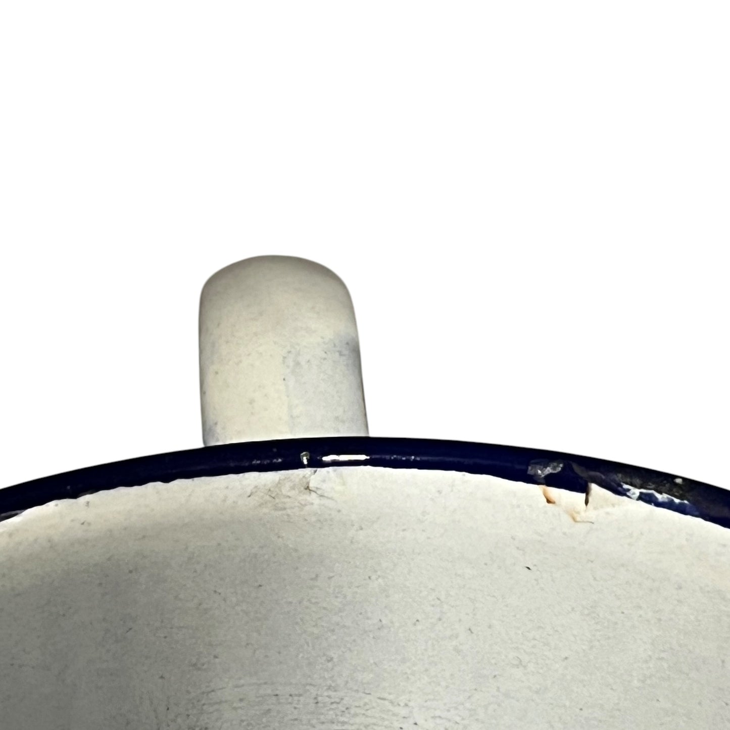 Close-up of the top edge of a white enamel pot with a dark blue rim and a matching white handle, shown against a plain white background.