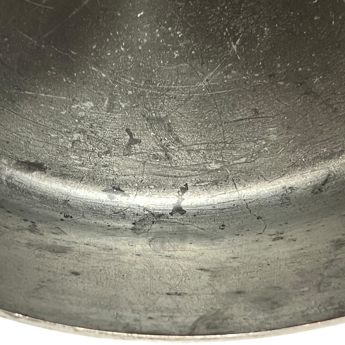 Close up of the inside of a French copper pan with tin lining on a white background