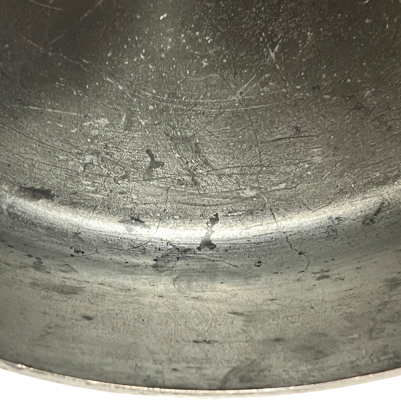 Close up of the inside of a French copper pan with tin lining on a white background