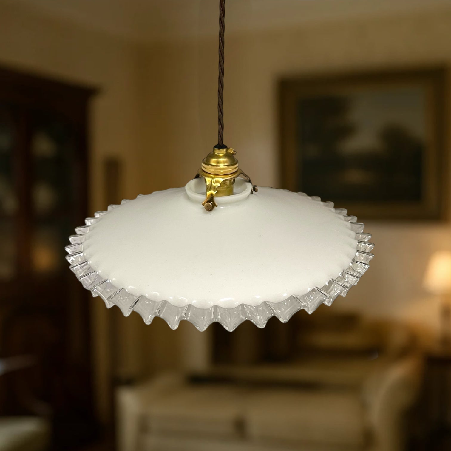 Vintage-style pendant light with white glass shade and brass fitting on a white background