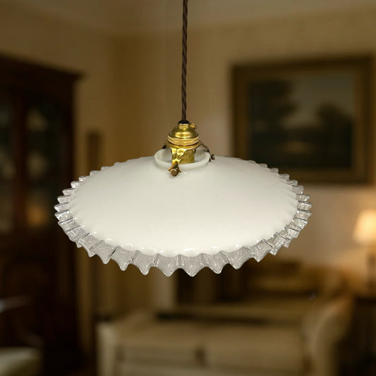 Vintage-style pendant light with white glass shade and brass fitting on a white background