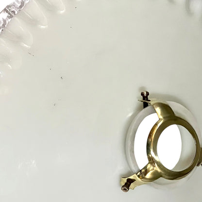 close up of white glass lampshade and brass gallery shown from above
