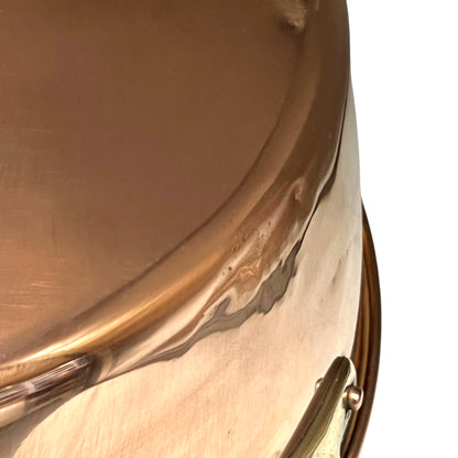 Close-up of a copper up cycled sink with brass handles on a white background.