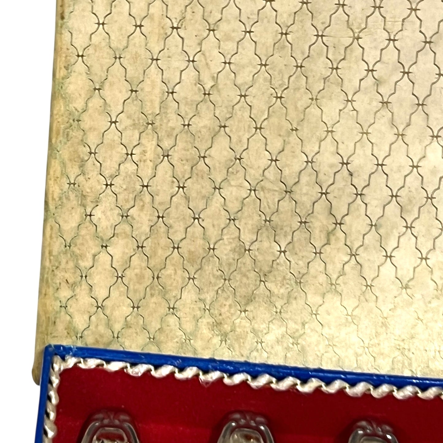 Close-up of a red and blue box containing 12 French dessert forks on a white background