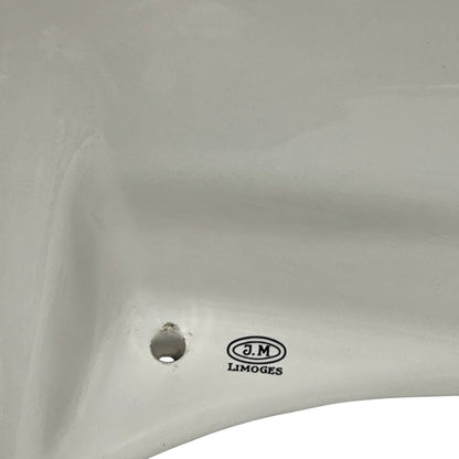 Close-up of a white ceramic sink basin showing a drain hole and the J.M. LIMOGES brand logo printed on the side.