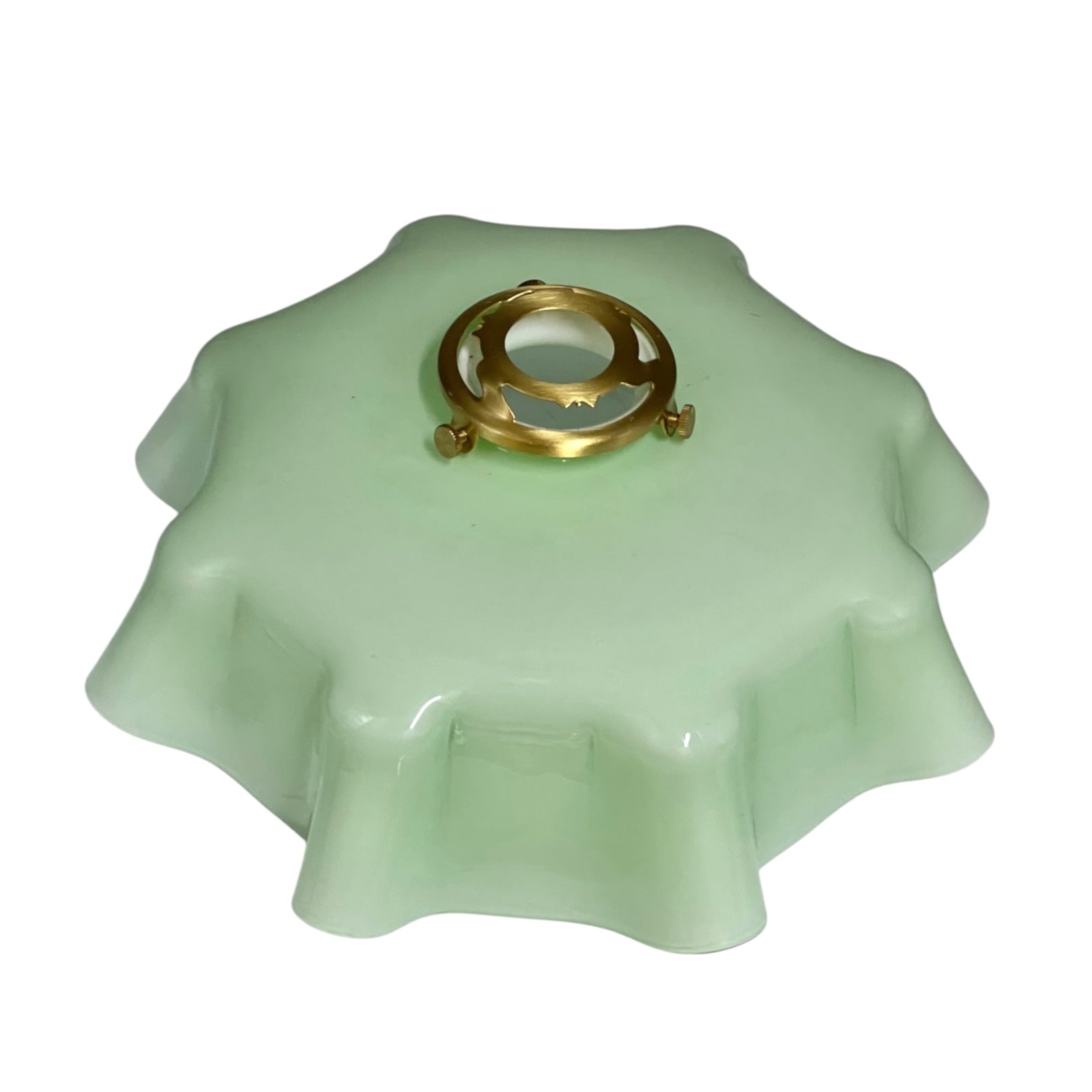 pale green milk glass lampshade with brass fittings on a white background