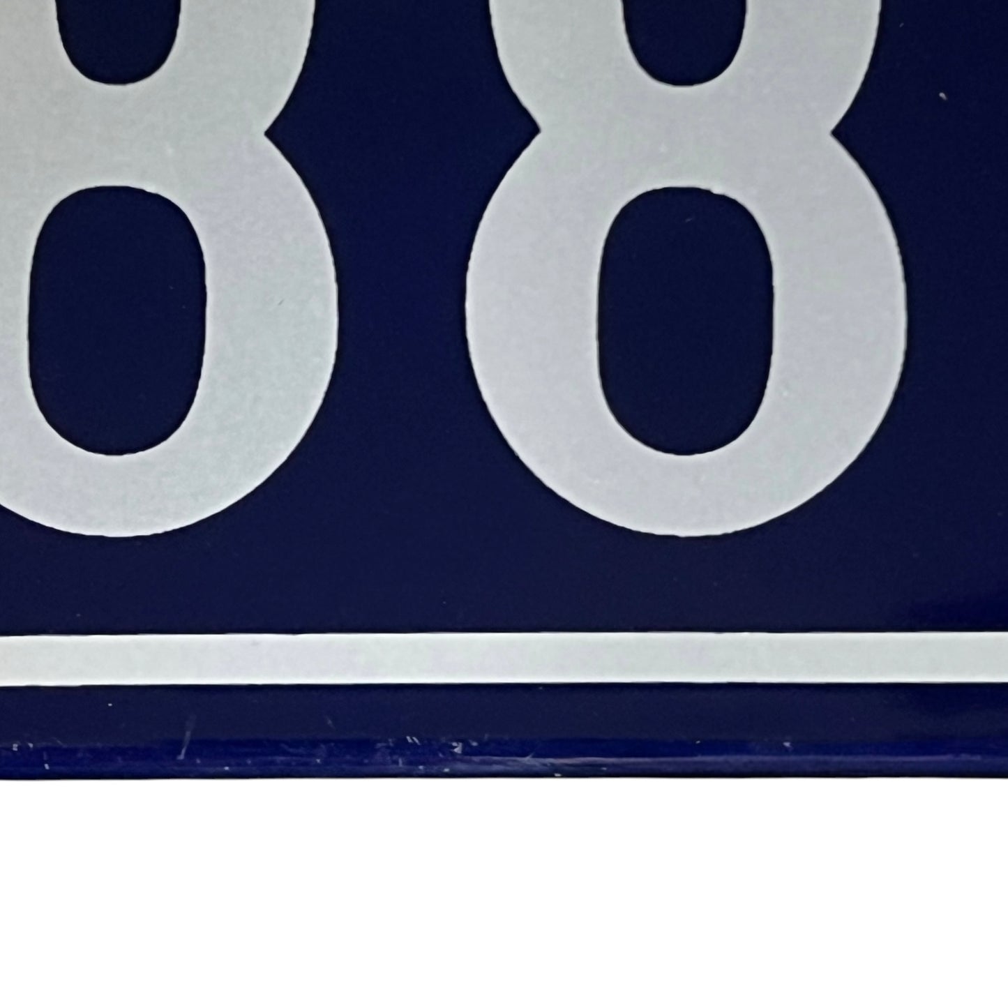 close up of a French vintage blue and white door number 88 on a white background 