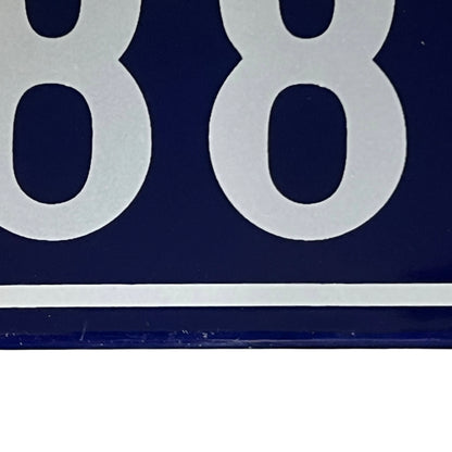 close up of a French vintage blue and white door number 88 on a white background 