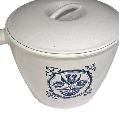 White enamelled cast iron pot with blue floral design and handle on a white background