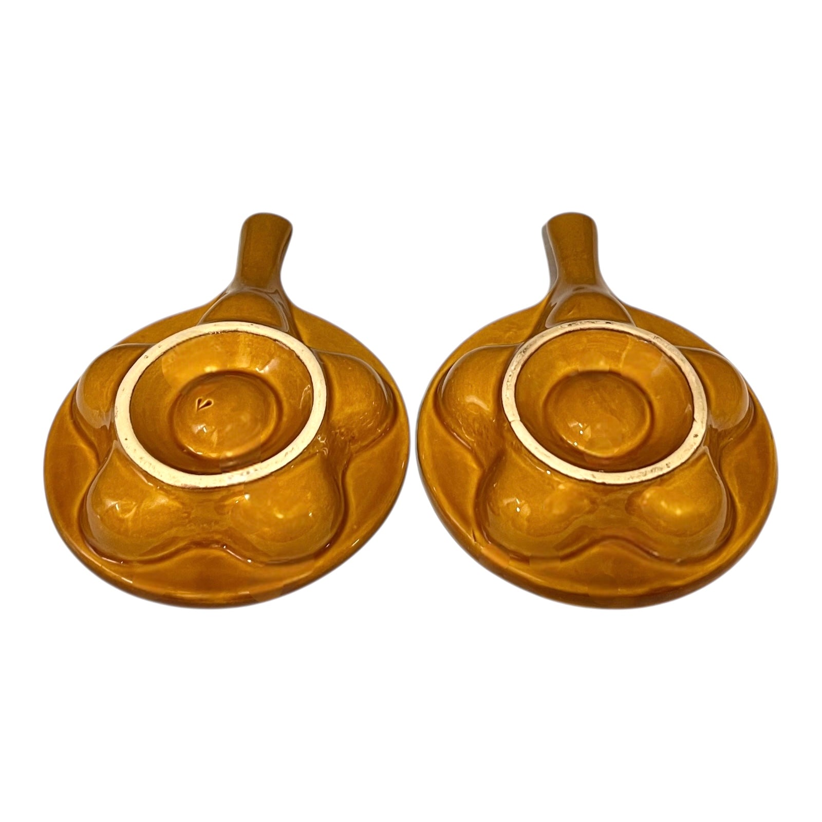 pair of amber-coloured French ceramic escargots plates with handles on a white background