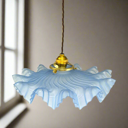 Vintage-style pendant light with blue glass shade, a brown twisted wire and gold metal fixture on a white background