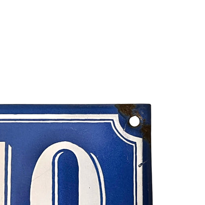 Close-up of a blue sign with white numbers on a white background