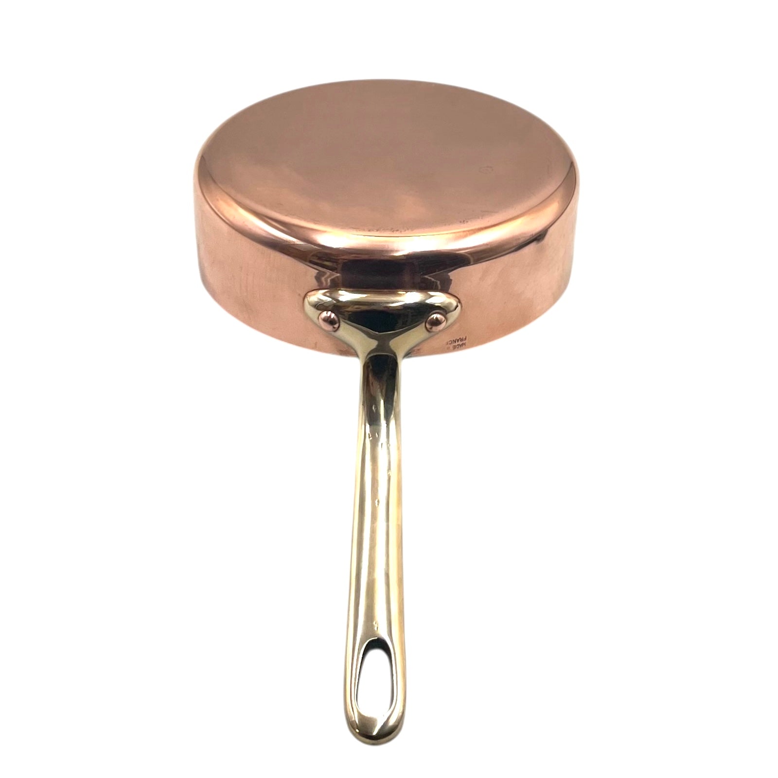 Copper saucepan with a brass handle on a white background