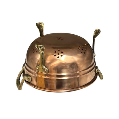 Close up of a copper colander with on a white background