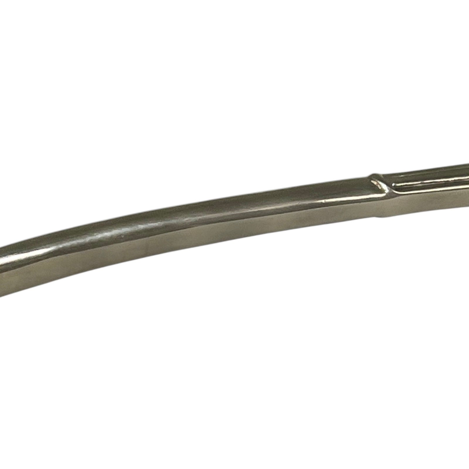 close up of a decorative Christmas tree shaped silver candle snuffer on a white background