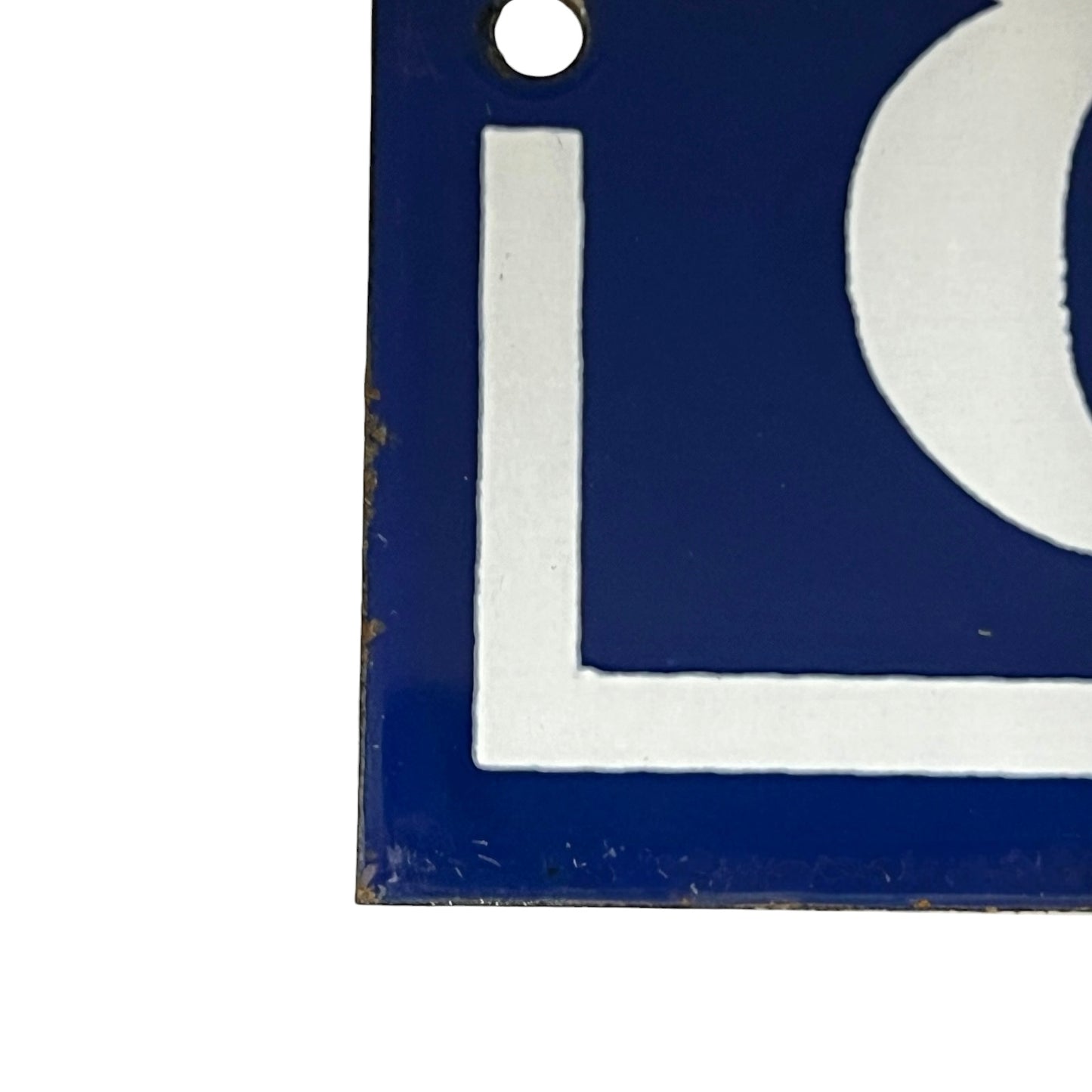 A close-up of a blue and white enamel sign showing part of a number 89 and a circular cutout, with a small metal hanging hole at the top.