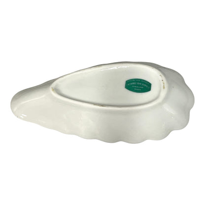 White ceramic dish with a green label on a white background