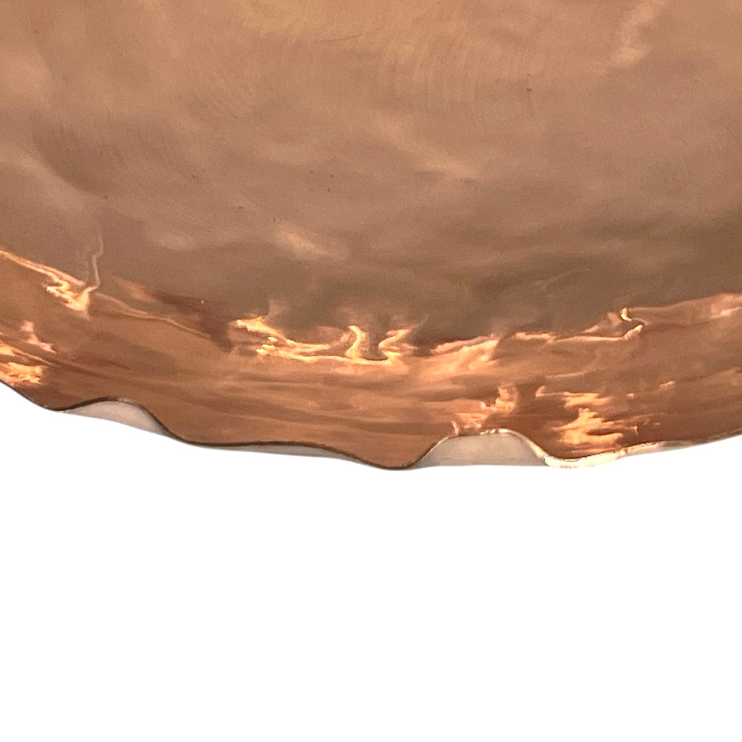Close-up of a copper fruit bowl surface with a white base