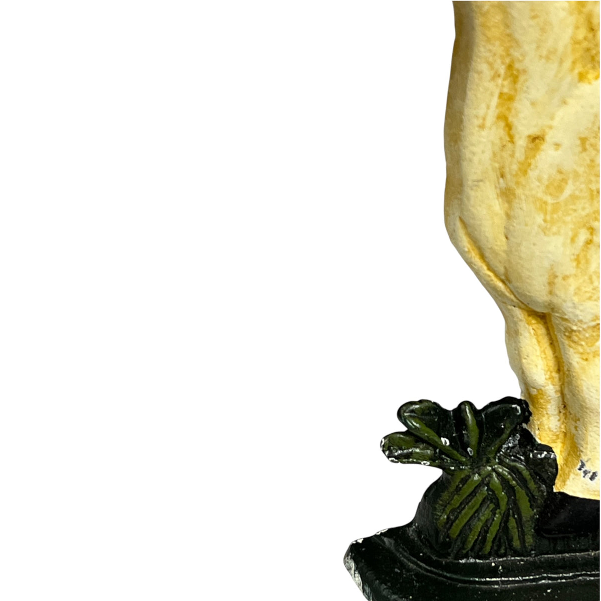 Close-up detail of a horse doorstop in cream and gold tones, standing on a dark pedestal with a green leafy ornament against a plain white background.