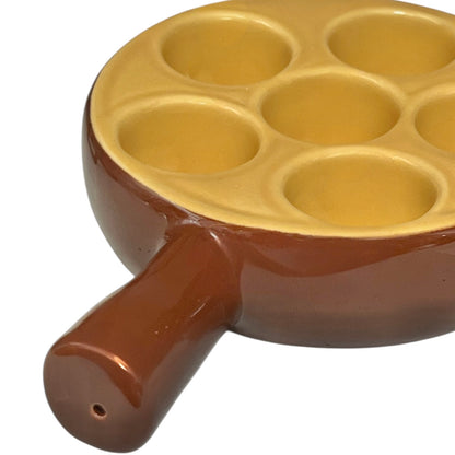 brown ceramic escargots dish with handles and a pale interior, on a white background.