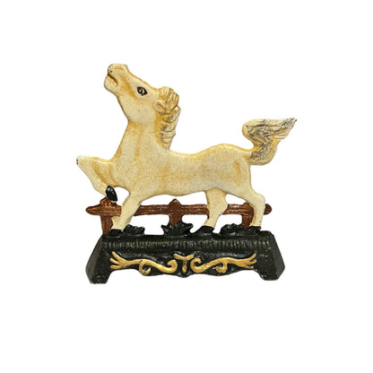 A decorative horse figurine standing on a black base with gold scrollwork and a brown fence detail, shown against a plain white background.