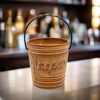 Small French Glacons ice cube bucket, drip glaze ceramic with a twisted metal handle makers stamp on base, bar scene in the background