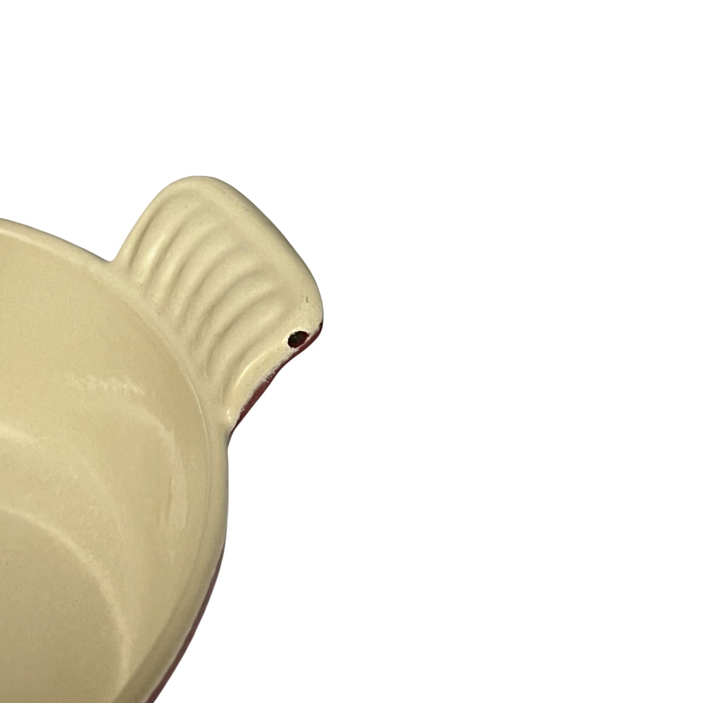 Close-up of a cream-colored ceramic handle with a ribbed texture and a small hole, shown on a plain white background.