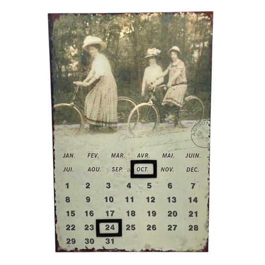 Calendar with vintage photo of three women on bicycles, set against a white background.