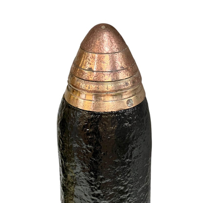 A close up of a WW1 18 pounder consisting of a brass shell, iron shrapnel and brass fuse on a white background 