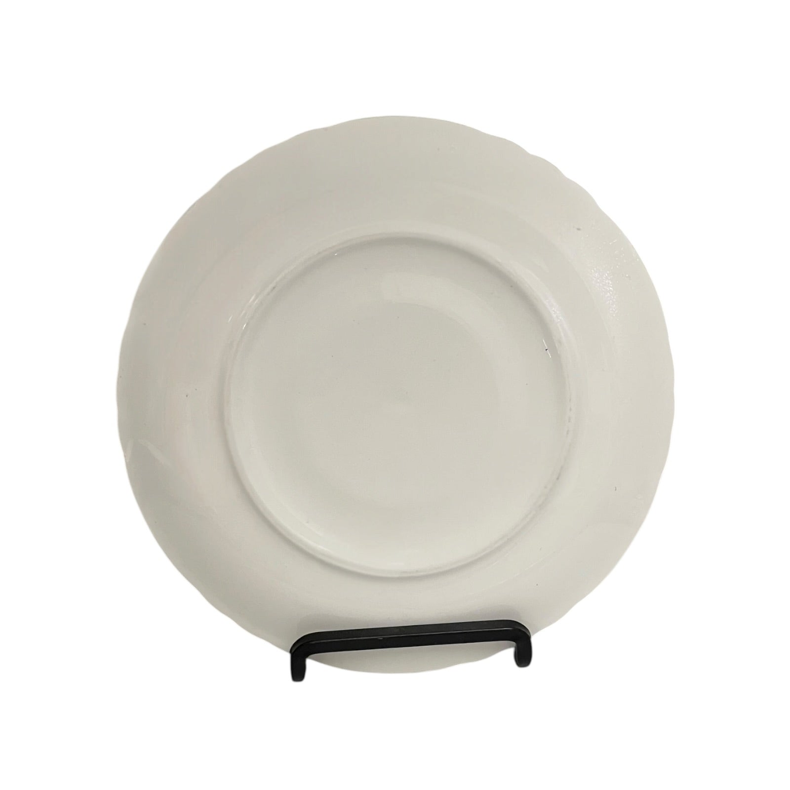 White ceramic plate on a stand against a white background