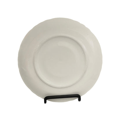 White ceramic plate on a stand against a white background
